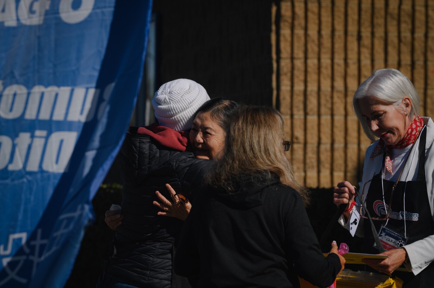 A first-time voter embraces a poll worker after casting their ballot for the 2024 General Election mid-morning on Nov. 5, 2024 at McKinley Elementary School in San Diego, Calif.