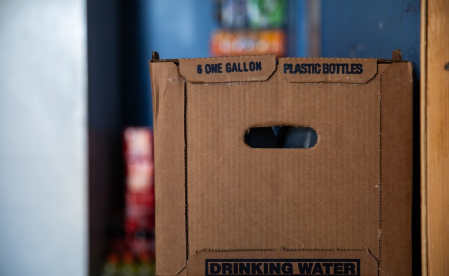 A crate with six gallons of water sits in the kitchen area of Entrika Zacariass' home at Oasis Mobile Home Park in Coachella Valley on Aug. 23, 2023.