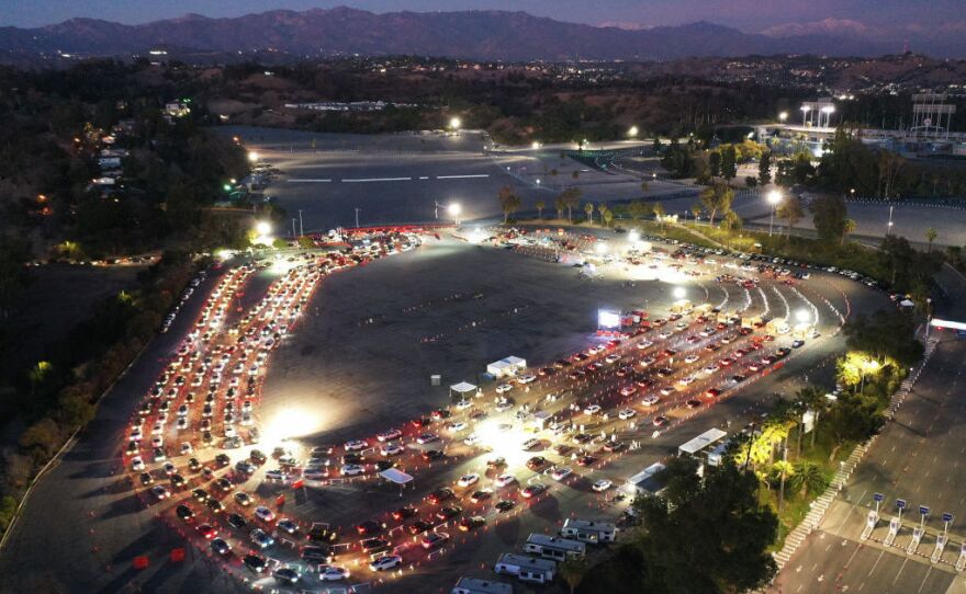 Cars line up at a COVID-19 testing site at Dodger Stadium in Los Angeles, California ahead of New Year's Eve. Many free testing sites have been overwhelmed by demand.