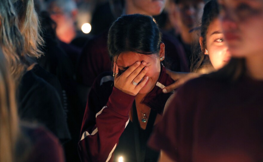 A woman cries during a candlelight vigil for the victims of the Wednesday shooting at Marjory Stoneman Douglas High School, in Parkland, Fla., on Thursday.