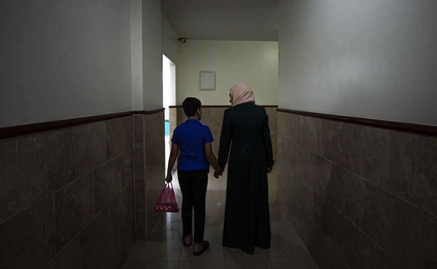 A mental health worker in Gaza walks with one of the children who participated in a psychodrama session aimed to help kids cope with the trauma of war.