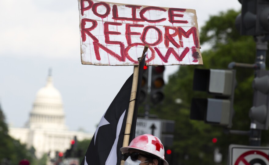 A demonstrator holds a placard during a march against racism and police brutality in Washington, D.C., on Saturday. Congressional Democrats have released a wide-ranging proposal aimed at overhauling policing