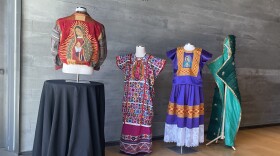 Works from the Mingei's "Fashioning an Icon" exhibit are shown on March 24, 2025. Local artist and fashion designer Claudia Rodríguez-Biezunski's jacket is shown at left. Local artist Diana Benavídez's green, piñata-style cape is shown on the far right.