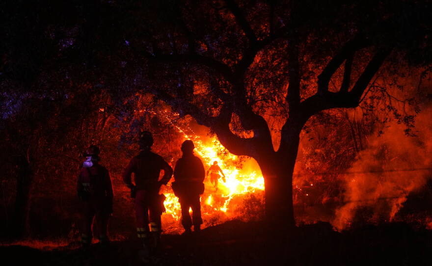 Firefighters use controlled burning to halt a wildfire that continues to spread near Cebreros, Ávila province, Spain, Tuesday, July 28, 2026.