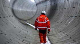 Construction worker inspects completed tunnel beneath the Thames, London, England. (undated photo)