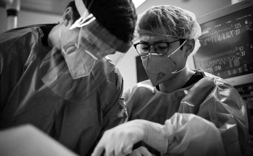 Dr. Nhu-Nguyen Le (right) supervises Dr. Chase Luther during a procedure.