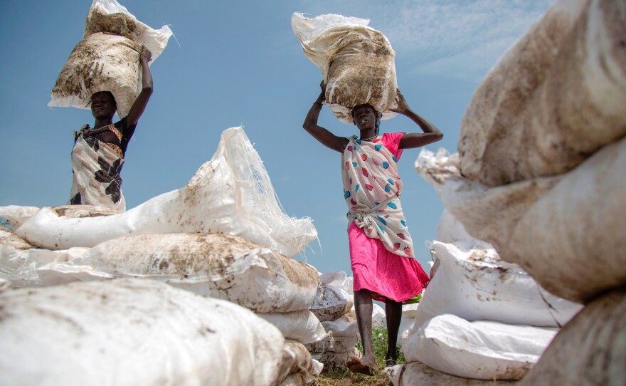 Women carry sacks of food, airdropped by the World Food Programme, this past summer in Jonglei, South Sudan.