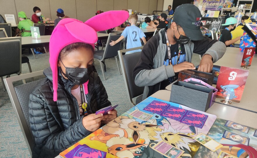 Fan Layla Heard strategizes her next move while playing a Pokemon card game, July 24, 2022.