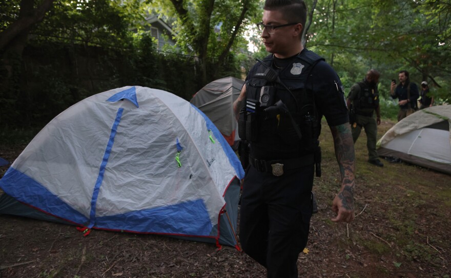 Law enforcement officers march through a gathering of activist at Brownwood Park who oppose the Atlanta Public Safety Training Center that protesters refer to as "Cop City," just as a vigil for killed activist Manuel "Tortuguita" Terán was set to begin informing them the park will be closed at 11PM in Atlanta, Georgia, U.S., June 24, 2023.