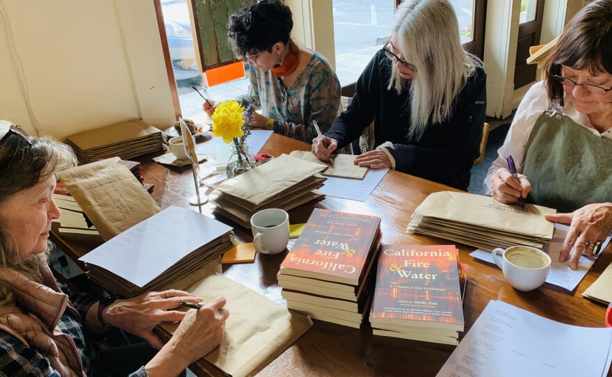 Judy Brackett Crowe, left, Janeen Singer, Kirsten Casey and Susanna Wilson mail out copies of Molly Fisk's <em>California Fire & Water: A Climate Crisis Anthology </em>in 2019. Both Fisk and Casey have served as poet laureate for Nevada County, Calif.