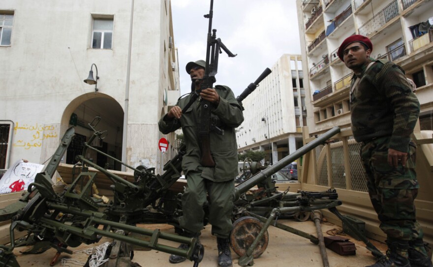 Gunmen prepared to fight against Libyan leader Moammar Gadhafi stand on a small military truck with weapons taken from a Libyan military base in Benghazi on Thursday.