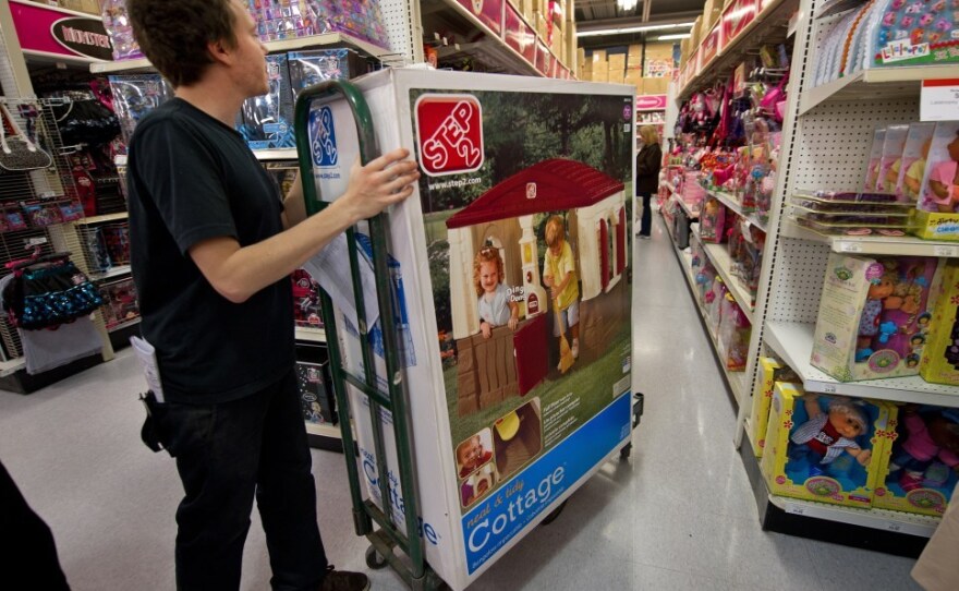 A stock clerk working on Black Friday moves merchandise into position at a Toys R Us store in Fairfax, Va. Retailers added 50,000 jobs in November.
