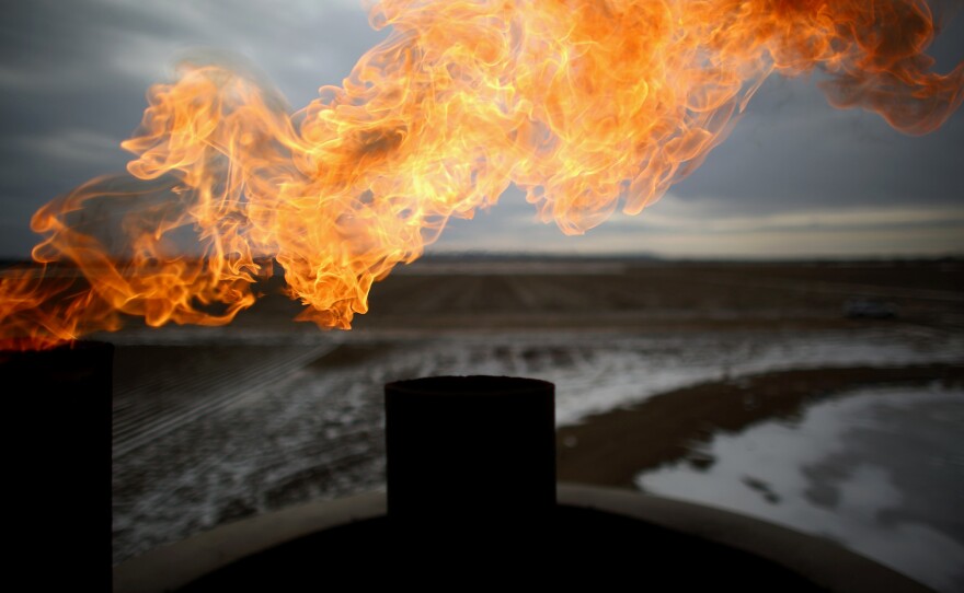 Natural gas is burned off at a oil well site near the city center of Sidney, Mont. The small town in eastern Montana, near the border of North Dakota, is bursting its seams with new residents coming to get a piece of the Bakken oil boom.