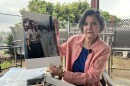 Chula Vista resident Sonia Lopez holds up photos from the Chicano Moratorium in Los Angeles, which she attended, Aug. 28, 2025.