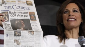 Republican presidential candidate Rep. Michele Bachmann, R-Minn., holds up a newspaper saying that she won the GOP Straw Poll as she speaks at the Black Hawk County Republican Party Lincoln Day Dinner in Waterloo, Iowa, Sunday, Aug. 14, 2011.