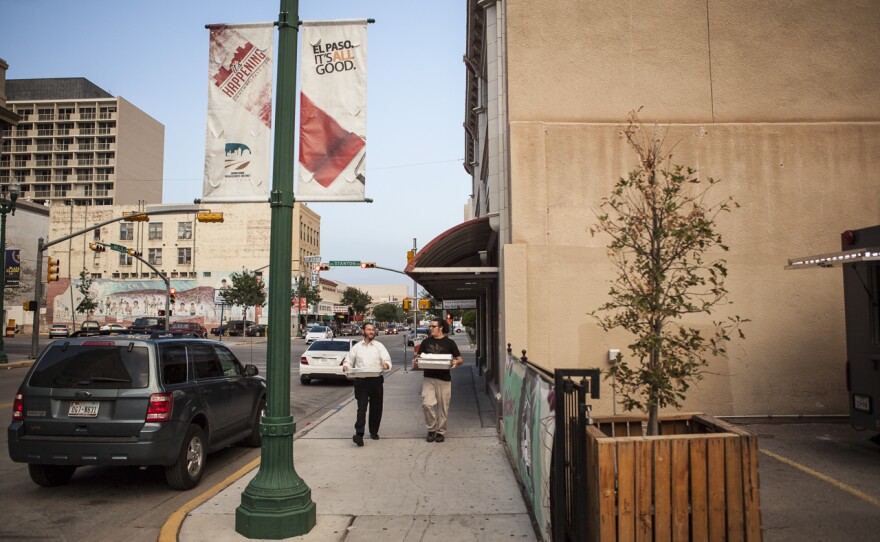 Rabbi Levi Greenberg (left) of Chabad Lubavitch El Paso and Rudy Parra (right) carry trays of food to the downtown food truck.