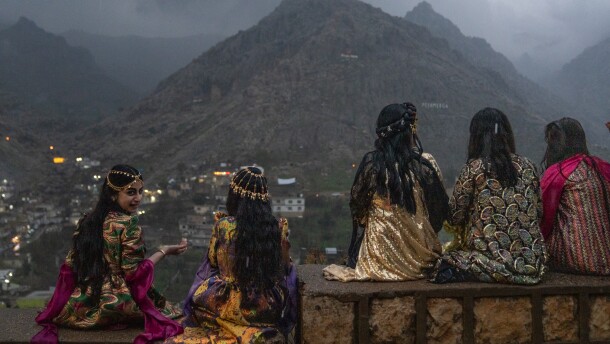 Girls sit on a wall to get a good vantage point of people walking up the mountains with flaming torches and fireworks for Nowruz in Akre, the Kurdish region of Iraq on Friday.