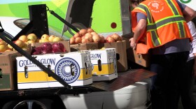 A San Diego Food Bank worker helping a food distribution network partner load her car with food, Oct. 22, 2025.