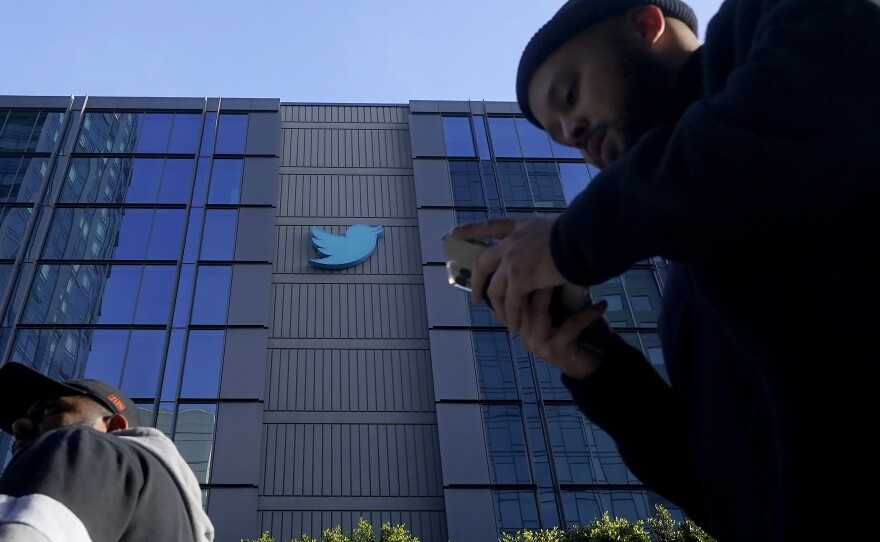 People walk outside Twitter headquarters in San Francisco, Friday, Nov. 4, 2022.
