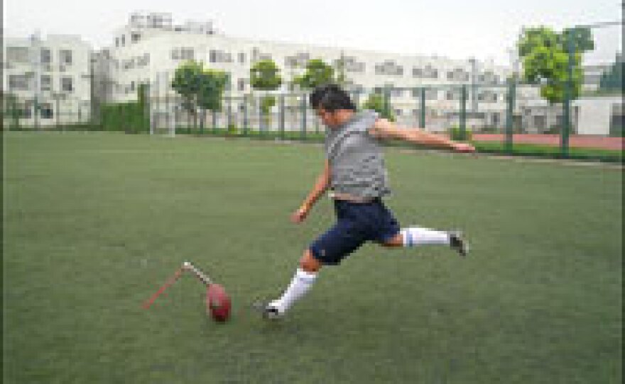 Gao Wei cuts a lonely figure practicing kickoffs on a deserted field at Shanghai Sports University following his return from training. He was the college soccer team's goalkeeper, but now he sees his future in American football.