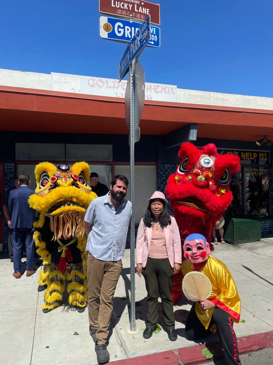 At the June 28 unveiling of "Lucky Lane," Matt Lyons and June Wong gathered beneath the new street sign as a lion dance troupe performed in honor of Lucky Wong.