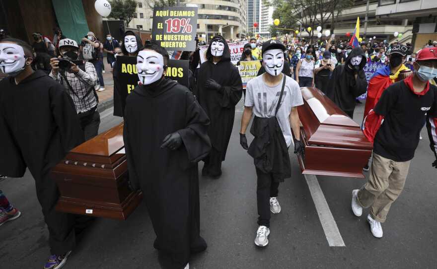 Protesters wearing Guy Fawkes masks carry empty coffins during a national strike to protest a government-proposed tax reform, in Bogotá, Colombia, on Wednesday.