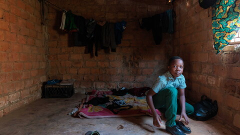 Alumbwe, who's 12 and lives in Zambia, gets ready for school. It's a 2 mile walk from his home. He and his brothers have lived without adult supervision since their parents died of AIDS earlier this year.