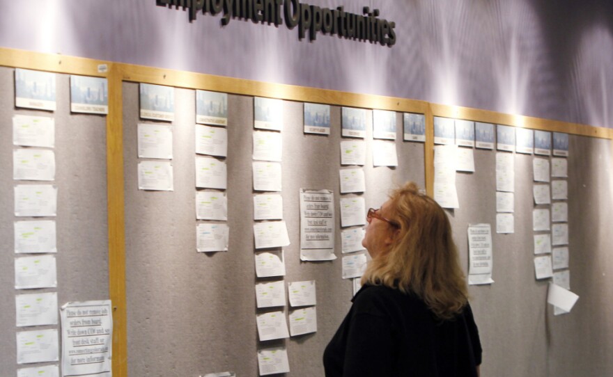 Lori Kamlet looks at posted job opportunities at a Denver employment office last Friday.