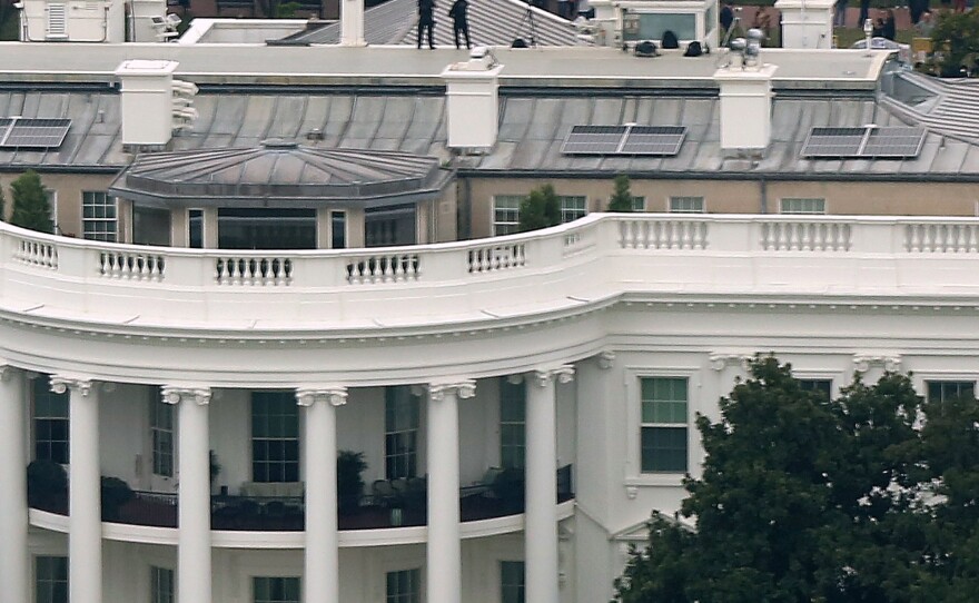 U.S. Secret Service countersniper team members stand on the roof of the White House on Monday.