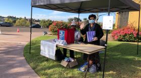 Poll workers stands outside the Malcom X Branch Library, a ballot drop off location in San Diego County. Oct. 31, 2020.