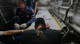 A relative of a victim in a music bar fire pays respect to the victim's body at a police hospital in Bangkok, Thailand, Tuesday, July 14, 2026.