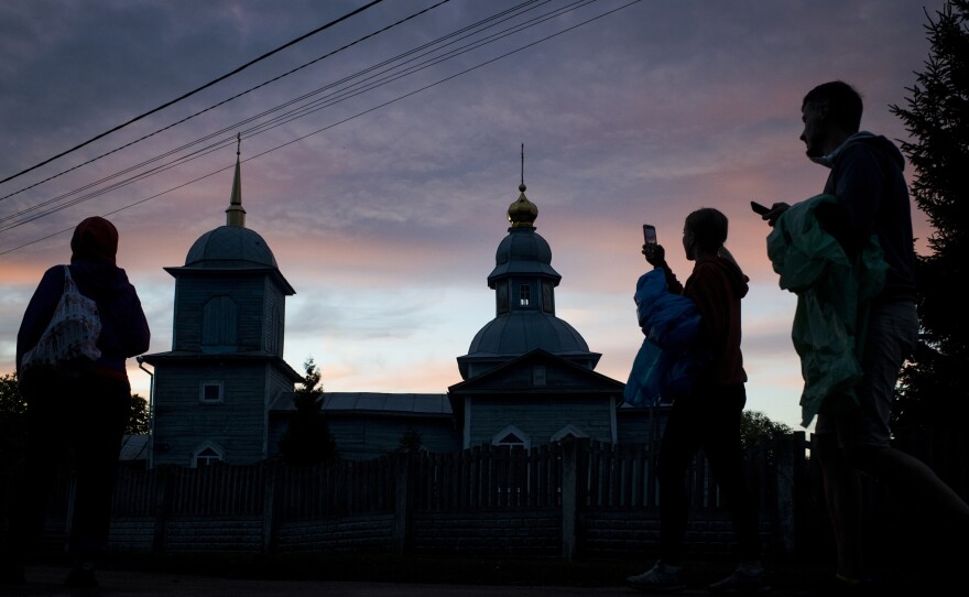 Repair Together volunteers photograph a church as the sun sets in Kolychivka on Oct. 1.