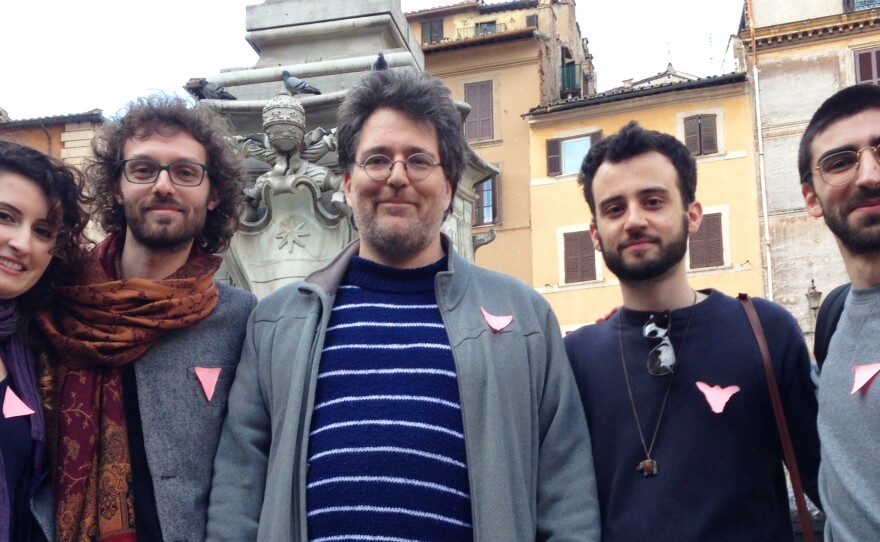 Counter-demonstrators in favor of LGBT rights wear pink triangles, reminiscent of those homosexuals were forced to wear in Nazi concentration camps.