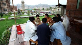 <strong>Sharing A Pizza:</strong> Students chat in an outdoor cafe on the campus of the Institute of Management Sciences. In the background are the mountainous tribal areas of the former Northwest Frontier province.