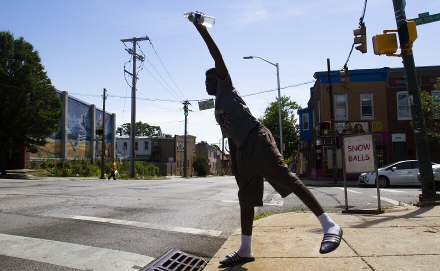 Boisey Neal, 12, sells bottled water to passing motorists in Baltimore's McElderry Park neighborhood on July 1. McElderry Park is the city's hottest neighborhood.