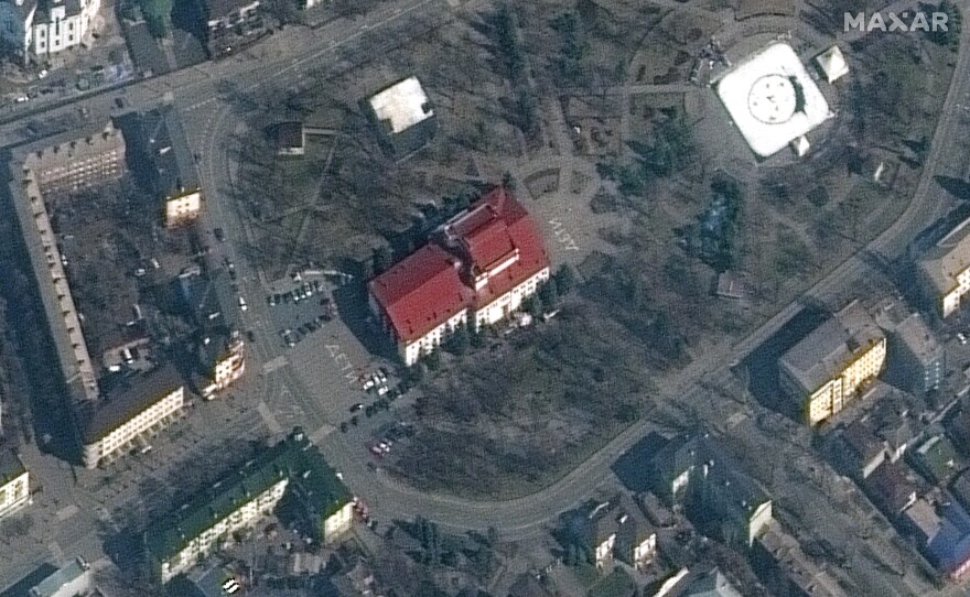 A satellite of the Mariupol theater from Monday, before it was bombed. The word "children" is written in white on the pavement.