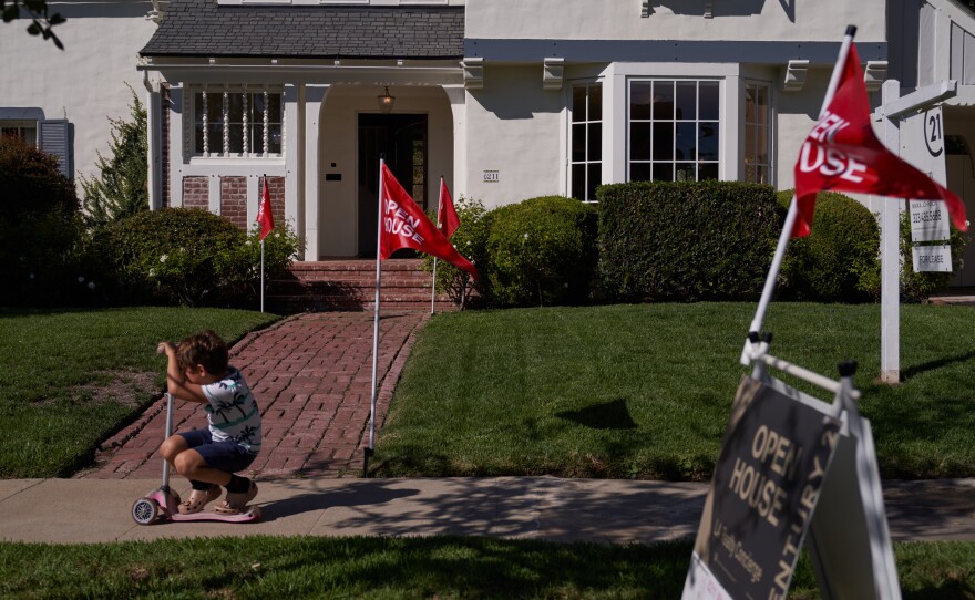 A child rides a scooter past an open house in Los Angeles.
