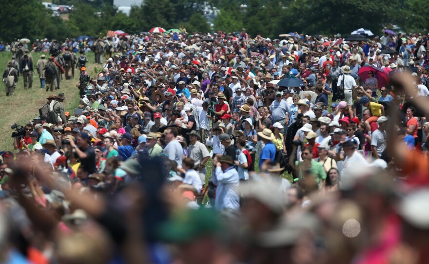 Thousands of spectators watch a Sunday re-enactment of Pickett's Charge, an assault waged on July 3, 1863. The National Parks Service spent approximately $500 million to prepare for the influx of tourists.