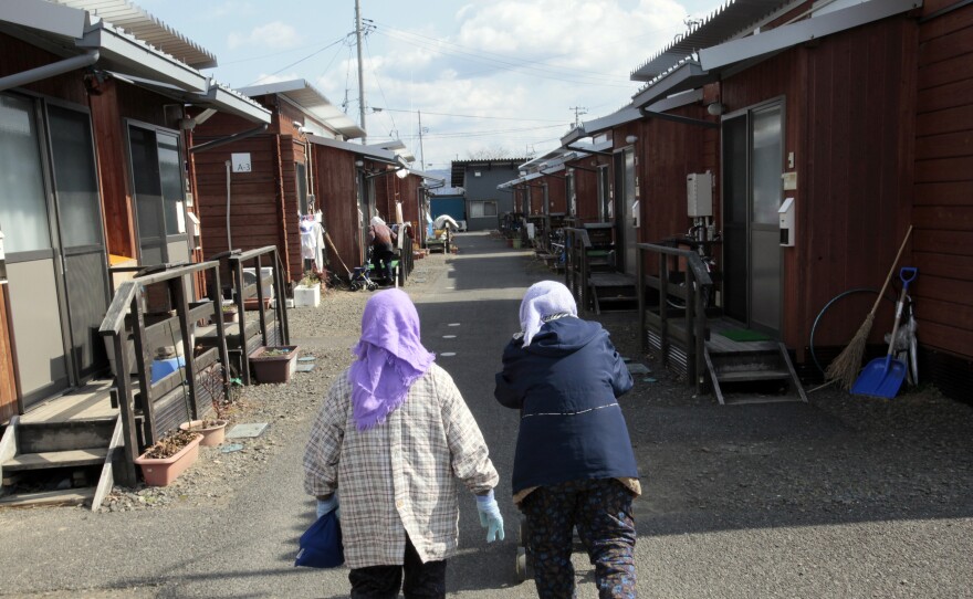 Elderly women walk together down a road lined with temporary homes in Fukushima prefecture, two hours from the radiation-affected coast.