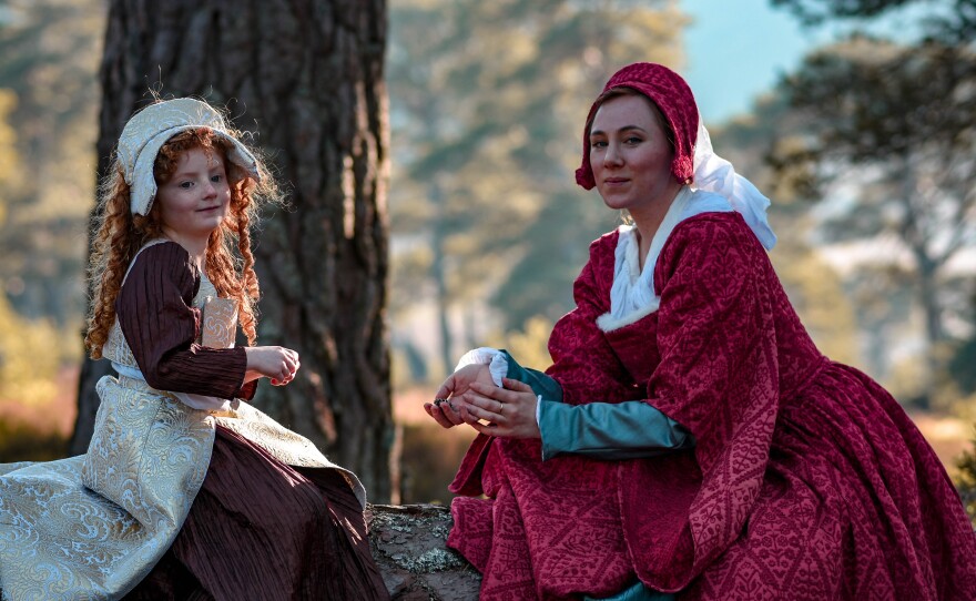 Drama reconstruction of a young Mary, Queen of Scots (pictured left), and her maid sitting on a fallen tree. Glenmore Estate, Aviemore, Scotland.