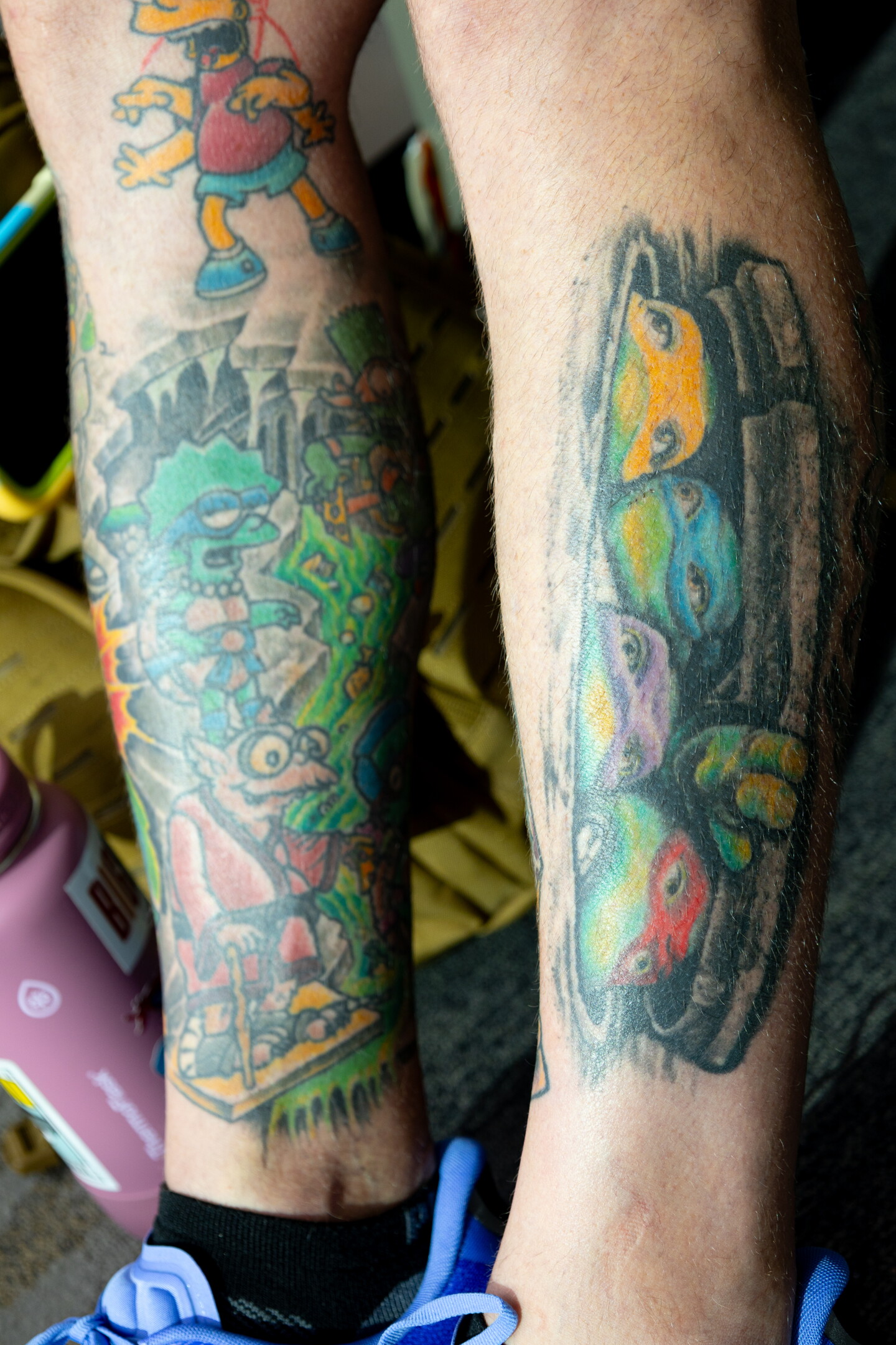 A Comic-Con attendee shows off leg tattoos featuring characters from "The Simpsons" in the style of the "Teenage Mutant Ninja Turtles," with the turtles peeking out from a sewer, July 24, 2026.