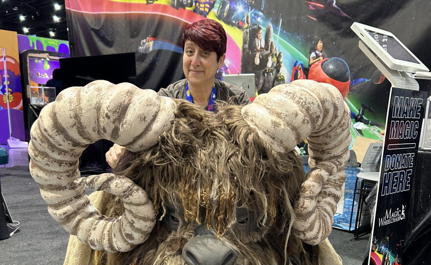 KPBS arts reporter Beth Accomando visits the Magic Wheelchair booth at Comic-Con and admires a Bantha costume created for children who use wheelchairs on July 22, 2026.