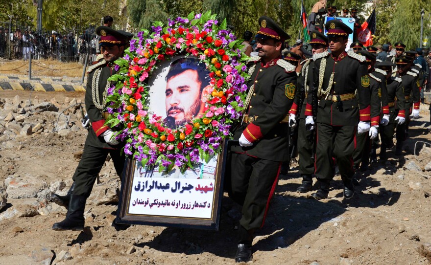 Guards of honor carry a photo of Brig. Gen. Abdul Raziq, Kandahar police chief, at his burial ceremony in Kandahar in October.