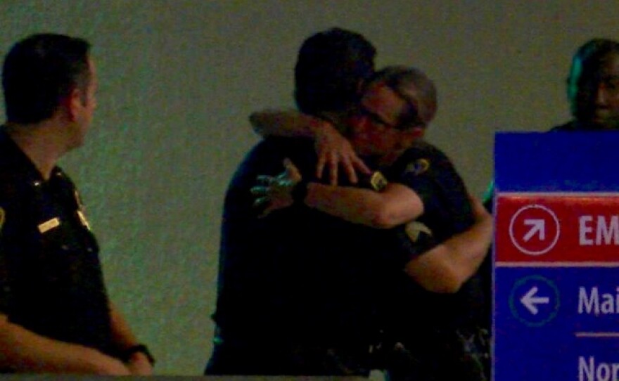 San Diego police embrace outside Scripps Mercy Hospital in Hillcrest after a gang unit officer was shot and killed in San Diego's Southcrest neighborhood, July 29, 2016.