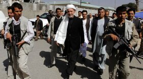 Afghan President Hamid Karzai (center), surrounded by bodyguards, walks through Kandahar city, south of Kabul, earlier this month. The purpose of the president's visit was to consult with and seek the support of locals for an upcoming U.S. and NATO military campaign there to drive out the Taliban. But the operation is meeting resistance.