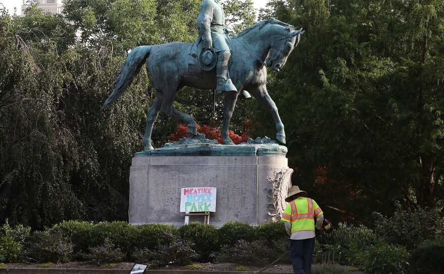 A homemade sign that says Heather Heyer Park rests at the base of the statue of Confederate Gen. Robert E. Lee in a downtown Charlottesville, Va. park on August 18, 2017. Heyer was killed by a neo-Nazi during a white nationalist rally.