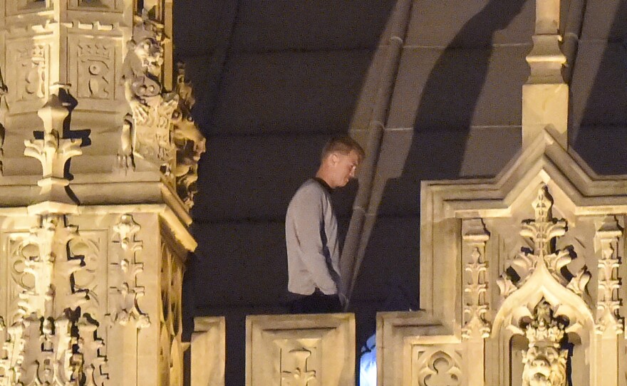 A trespasser stands and walks along the roof at House of Commons early Sunday morning in London. The unidentified man was taken into custody after spending about eight hours wandering around the roof of the Palace of Westminster.
