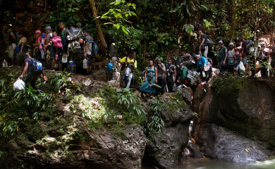 Migrants from Haiti on a crevasse along a river, as they make their way from Colombia to Panama through the Darién jungle.