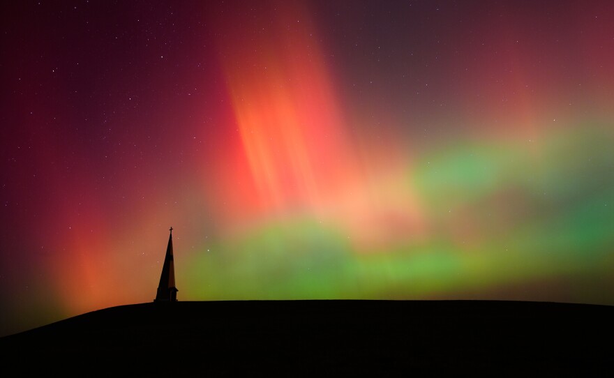 FILE - Northern lights fill the sky behind the Saint Joseph the Woodworker Shrine, near Valley Falls, Kan., Nov. 11, 2025.