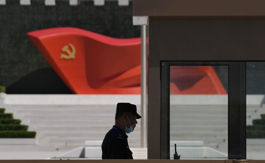 A security guard stands near a sculpture of the Chinese Communist Party flag at the Museum of the Communist Party of China on May 26, 2022, in Beijing. China said it was conducting military exercises Saturday, off its coast opposite Taiwan.